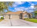 A beautiful home with a stone facade, well-kept lawn, and a spacious three-car garage at 1411 Ellis Fallon Loop, Oviedo, FL 32765