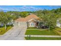 Aerial view of a well-maintained home showcasing the landscaped front yard and spacious driveway at 1411 Ellis Fallon Loop, Oviedo, FL 32765