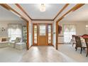 Inviting foyer featuring tile flooring, wood trim, and a decorative front door with sidelights at 1432 Northridge Dr, Longwood, FL 32750