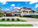 Attractive two-story home with a red tile roof, attached garage, and manicured landscaping at 15469 Shorebird Ln, Winter Garden, FL 34787