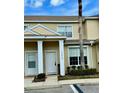 Two-story townhome featuring tan exterior, neat front yard and mature tree at 17519 Blessing Dr, Clermont, FL 34714