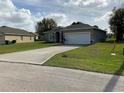 A cozy single-story home with a long driveway and a two-car garage at 1958 Sawfish Dr, Kissimmee, FL 34759