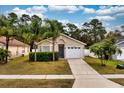 Cozy home featuring a one-car garage, blue front door, and lush landscaping at 2209 Hannah Ln, Orlando, FL 32826