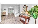 Elegant foyer with a wooden console table, decorative mirror, and beautiful tile flooring leading into the living space at 2246 Rush Bay Way, Orlando, FL 32824