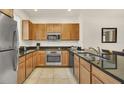 Kitchen featuring stainless steel appliances, granite counters and wood cabinets at 2647 Corvette Ln, Kissimmee, FL 34746