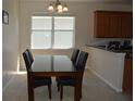 Cozy dining area featuring a glass-top table with black chairs and a large window with natural light at 2657 Youngford St, Orlando, FL 32824