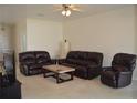 Spacious living room featuring neutral carpeting and a seating area with a leather sofa set and coffee table at 2657 Youngford St, Orlando, FL 32824