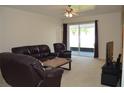 Comfortable living room with plush leather furniture, neutral carpet, and sliding glass doors to the backyard at 2657 Youngford St, Orlando, FL 32824