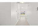 Bright hallway with tiled flooring leading to a room with a view of the backyard at 3201 Sweet Acres Pl, St Cloud, FL 34772