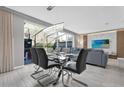 Dining area with a glass table and sleek chairs, adjacent to a living room and patio, ideal for gatherings at 4431 Le Reve Ct, Kissimmee, FL 34746