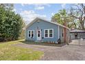 Charming blue home featuring white trim, an American flag, and well-maintained landscaping at 655 W Date St, Lake Wales, FL 33859