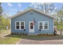 Charming blue home featuring white trim, an American flag, and well-maintained landscaping at 655 W Date St, Lake Wales, FL 33859