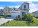 Stylish two-story home with lush landscaping, modern architectural details, and a welcoming blue door at 659 Daring Dr, Davenport, FL 33837