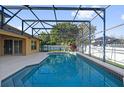 Inviting in-ground pool featuring a screened enclosure and ample patio space at 729 Strihal Loop, Oakland, FL 34787