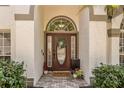 Close up of the front door with decorative glass and a welcome mat on a brick paver path at 8534 Black Mesa Dr, Orlando, FL 32829