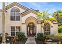 Inviting front entrance with a decorative wreath, arched windows and fresh landscaping at 8534 Black Mesa Dr, Orlando, FL 32829