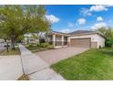 A well-maintained single-Gathering home with a brick driveway, lush lawn, and a two-car attached garage at 8813 Tatara, Orlando, FL 32836