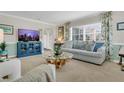 Comfortable living room featuring a plush sofa, modern entertainment center, and abundant natural light at 936 N Baker St, Mount Dora, FL 32757