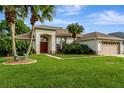 Lovely home with lush lawn, palm trees, a two-car garage and covered entry exudes curb appeal at 1154 Seneca Trl, St Cloud, FL 34772