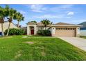 Charming single-story home featuring a well-manicured lawn, attached garage and vibrant tropical landscaping at 1154 Seneca Trl, St Cloud, FL 34772