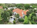 Aerial view of a house with a private pool and a red tile roof surrounded by lush landscaping at 12820 Butler Bay Ct, Windermere, FL 34786