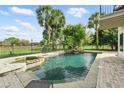 A luxurious pool with a waterfall feature, surrounded by tropical landscaping, offering a private oasis at 12820 Butler Bay Ct, Windermere, FL 34786