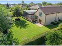 Expansive backyard with a screened-in pool, lush lawn, mature trees, and a patio area at 12860 Jacob Grace Ct, Windermere, FL 34786