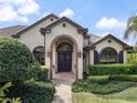 Inviting front entrance featuring double doors, brick archway, and manicured bushes flanking the walkway at 12860 Jacob Grace Ct, Windermere, FL 34786