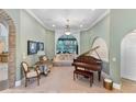Elegant living room with a grand arched window, plush seating, and a beautiful piano at 12860 Jacob Grace Ct, Windermere, FL 34786