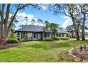 Landscaped front yard with mature trees framing a neutral colored home with a dark roof at 137 Spring Chase Cir, Altamonte Springs, FL 32714