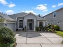 Inviting home entrance with well-maintained landscaping, a charming bench, and neutral-colored exterior at 15144 Spinnaker Cove Ln, Winter Garden, FL 34787