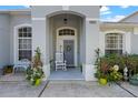 Close-up of home entrance with a rocking chair and lush potted plants enhancing its curb appeal at 15144 Spinnaker Cove Ln, Winter Garden, FL 34787