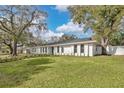 Spacious front yard view of a long white home with a bright blue front door at 1536 Errol Pkwy, Apopka, FL 32712