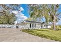 Rear view of a bright white single story home with a long driveway and ample parking at 1536 Errol Pkwy, Apopka, FL 32712