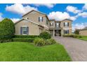 Charming two-story home featuring lush landscaping and a paver driveway at 1722 Lake Sims Pkwy, Ocoee, FL 34761