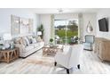 Inviting living room with a neutral color palette, plush seating, and sliding glass doors to the backyard at 2305 Sirena Ln, Mount Dora, FL 32757