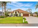 Beautiful one-story home boasts manicured lawn, decorative landscaping, and a two-car garage at 2726 Babbitt Ave, Orlando, FL 32833