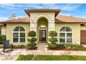 Inviting entryway features an arched entrance, lush landscaping, and a decorative front door at 2726 Babbitt Ave, Orlando, FL 32833