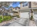 Charming townhome featuring an attached garage, manicured landscaping, and a welcoming facade at 2847 Metro Sevilla Dr # 103, Orlando, FL 32835