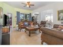 Spacious living room with tile floors, ceiling fan, and ample natural light, perfect for relaxation at 3726 Mount Hope Loop, Leesburg, FL 34748