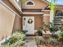 Up close shot of the front door with well manicured landscaping with an arch window above the door at 380 Morning Glory Dr, Lake Mary, FL 32746