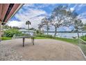 Spacious tiled back patio with white metal railing overlooking a serene lake view and mature trees at 443 Lakewood Dr, Winter Park, FL 32789