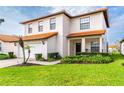 Charming two-story home with a terra cotta roof, well-manicured lawn, and a spacious two car garage at 502 Summer Place Loop, Clermont, FL 34714