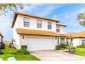 Charming two-story home with a terra cotta roof, well-manicured lawn, and a spacious two car garage at 502 Summer Place Loop, Clermont, FL 34714