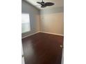 A clean, empty room with hard wood floors, a ceiling fan, and a window at 527 Buckhaven Loop, Ocoee, FL 34761