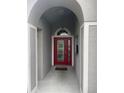 A beautiful red front door surrounded by a gray trim and glass window panes at 527 Buckhaven Loop, Ocoee, FL 34761