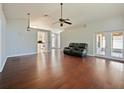 Spacious living room with hardwood floors, neutral wall paint, modern ceiling fan, and natural lighting at 527 Buckhaven Loop, Ocoee, FL 34761