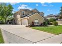 Stunning two-story home with a spacious three-car garage and lush green lawn on a sunny day at 558 Osprey Lakes Cir, Chuluota, FL 32766