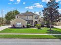 Beautiful two-story home featuring a lush green lawn and a serene, tree-lined driveway at 558 Osprey Lakes Cir, Chuluota, FL 32766