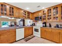 Well-lit kitchen featuring wooden cabinets, modern appliances, granite counters, and tile flooring at 600 Heather Brite Cir, Apopka, FL 32712